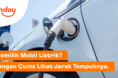 Mobil listrik berwarna putih yang sedang diisi daya dengan kabel charger terpasang pada port pengisian daya. Di sudut kiri atas terdapat logo Sunday dan di bagian bawah terdapat spanduk oranye bertuliskan "Memilih Mobil Listrik? Jangan Cuma Lihat Jarak Tempuhnya."